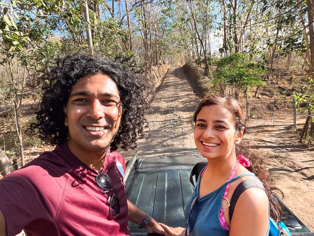Couple standing at the back of a 4X4 pickup truck, on the way to the trailhead of La Leona waterfall hike.
