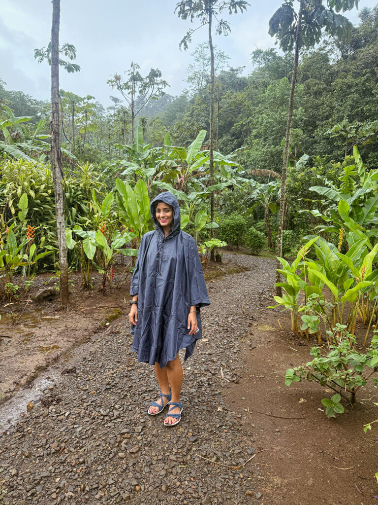 A woman in poncho in a garden trail in private nature reserve in Bijagua, Costa Rica.