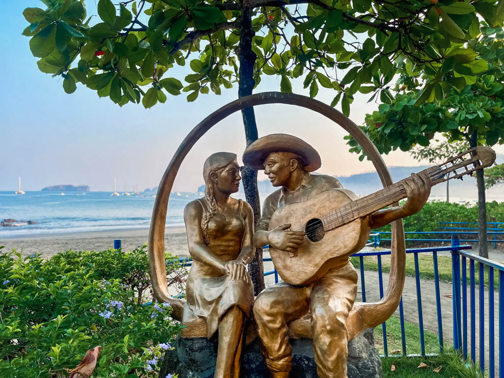 A sculpture of a couple, now painted in bronze in 2024, by the beach at Playa del Coco in Costa Rica.