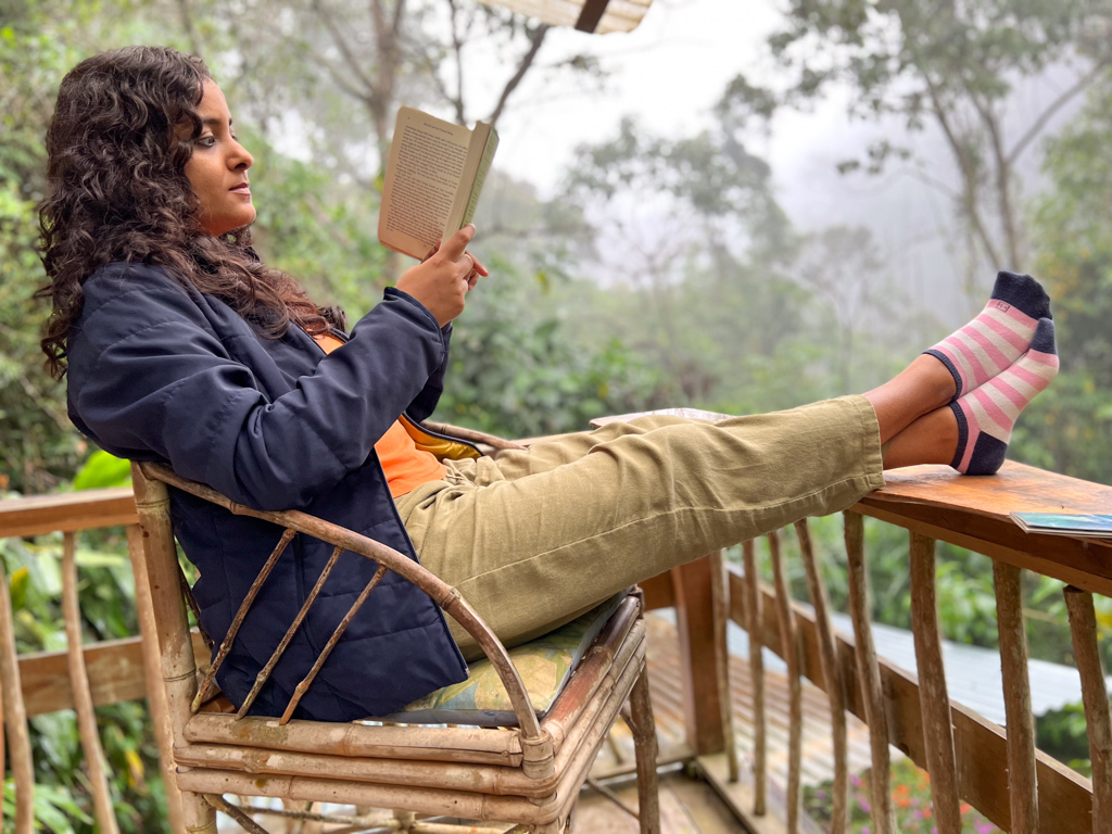A woman reading a book on the balcony of an Eco lodge in Costa Rica.
