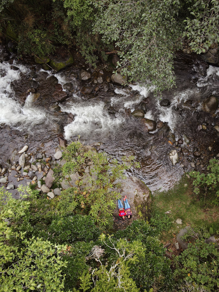 Aerial view of a man and a woman lying on a rock beside the Savegre river in San Gerardo de Dota in Costa Rica.