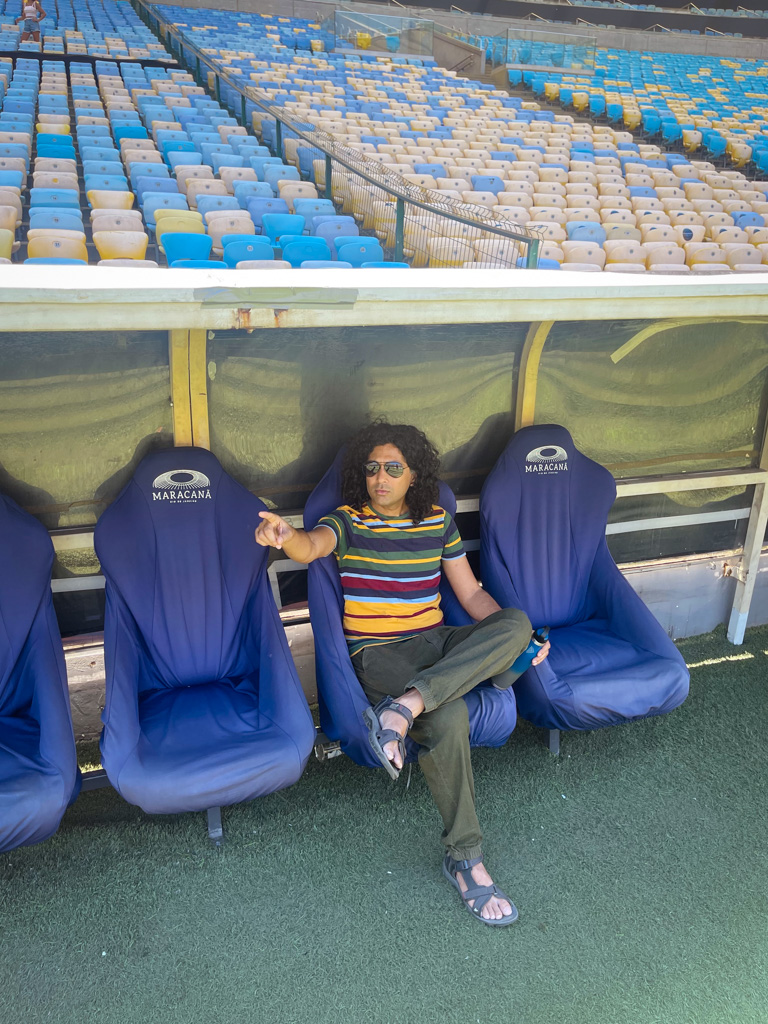 Man sitting at the dugout of Maracana Stadium.