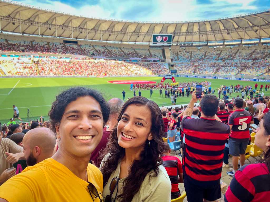 Man and woman posing for a selfie during the Flamengo-Fluminense match at Maracana Stadium.
