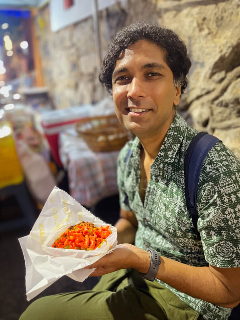 Man, with Acaraje Completo in his hand on the streets of Rio de Janeiro, Brazil.