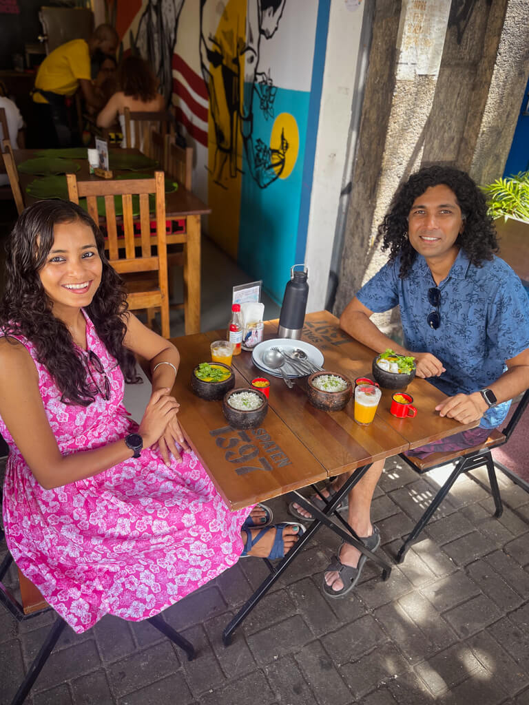Couple seated at an outdoor table at a restaurant in Little Africa neighborhood of Rio de Janeiro.