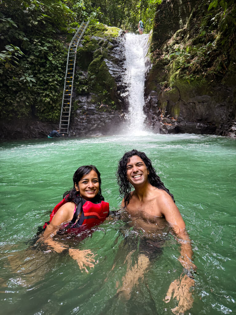 A woman and a man posing for a photo in the natural swimming hole by the Uvita Waterfall in Costa Rica. This is one of the locations visited during the Paddle 9 Full Day Waterfall Tour from Manuel Antonio.