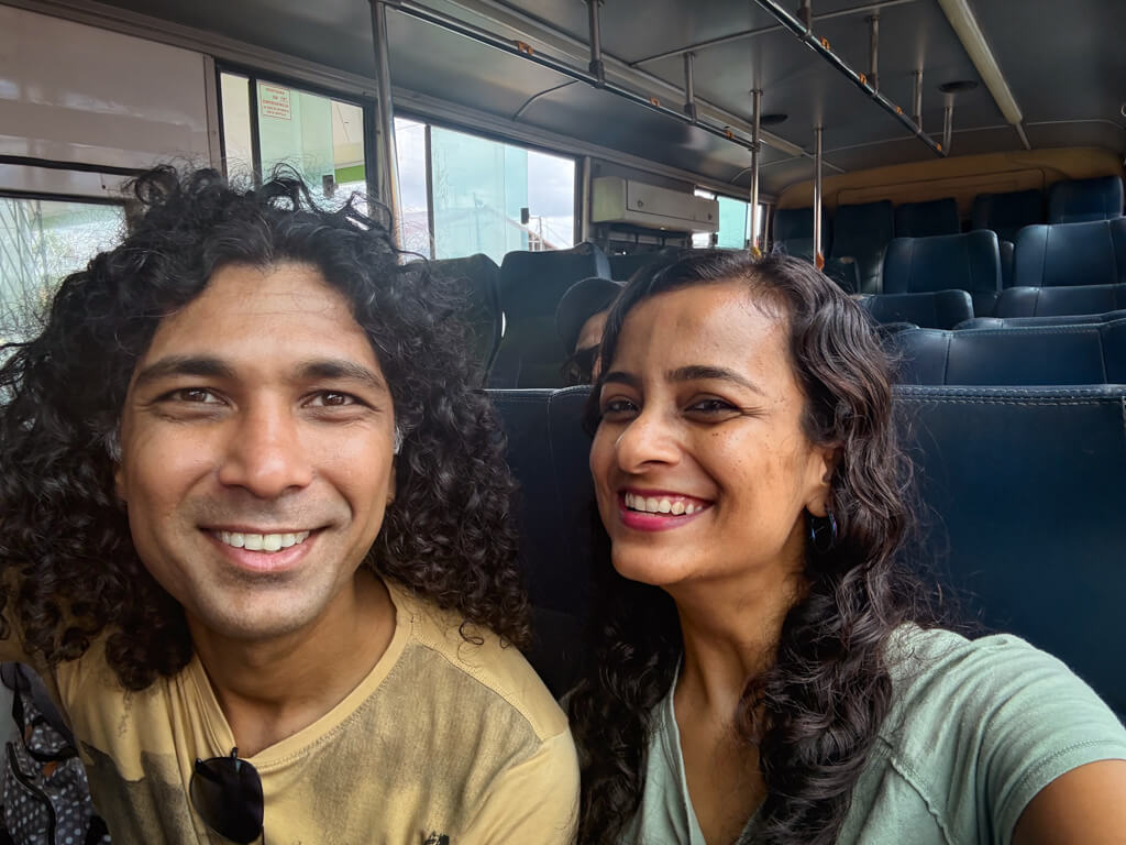 A man and a woman posing for a selfie, seated inside the bus from Cariari to Pavona, the boarding point for boats to Tortuguero.