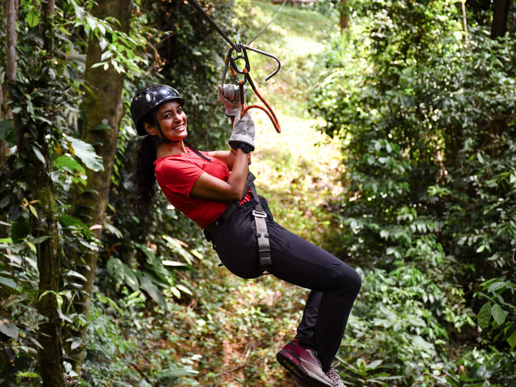 A woman smiling while doing El Santuario Canopy Tour in Manuel Antonio, Costa Rica. 