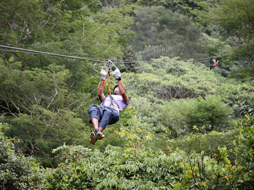 A man and a woman on the twin zipline of El Santuario Canopy Tour in Manuel Antonio, Costa Rica.