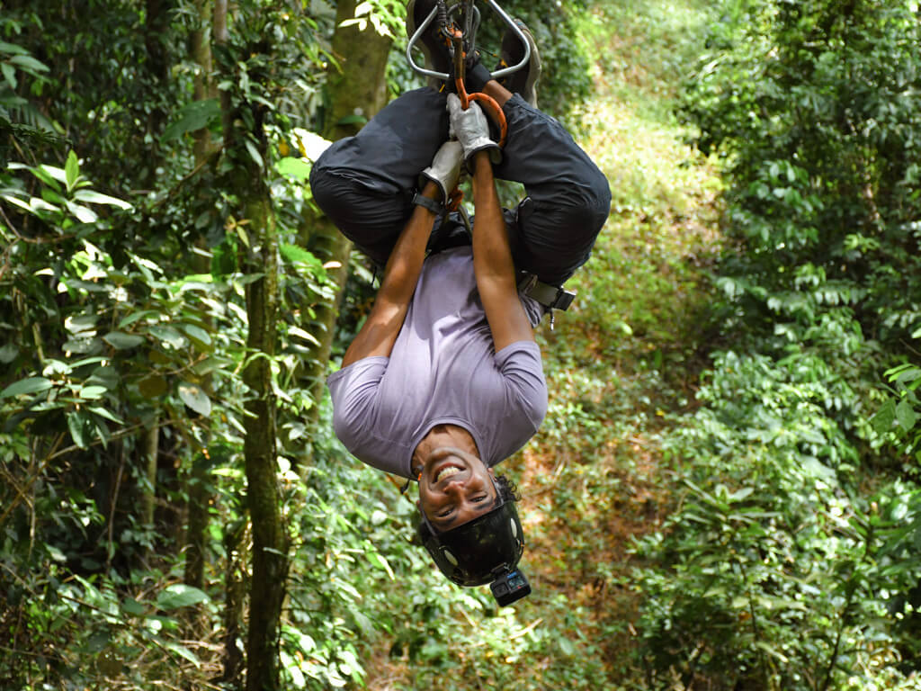 A man upside down on one of the ziplines of El Santuario Canopy Tour.