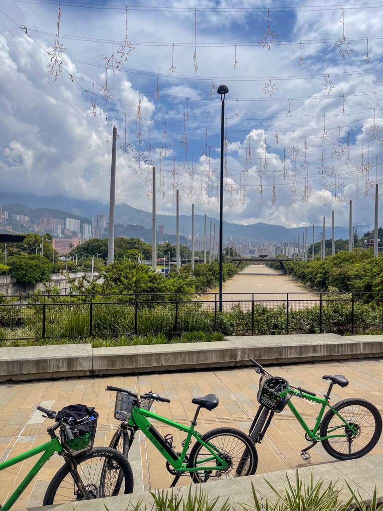 Views of Medellin from Parque del Rio, with bikes parked on a bridge over the Medellin River.