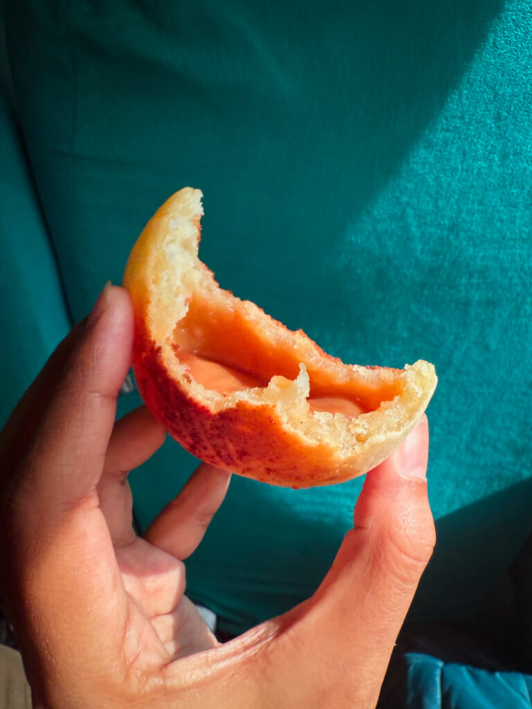 A woman holding a pan de queso relleno con arequipe, inside a bus from Medellin to Jardin.
