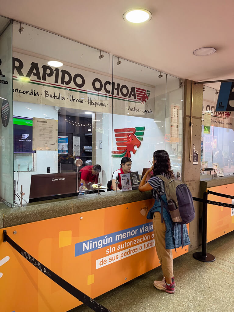 A woman, doing the check-in at Rapido Ochoa ticket counter at the Terminal del Sur in Medellin.