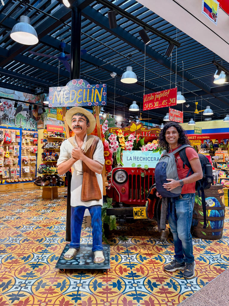 A man standing beside a mannequin at a souvenir store at the Medellin Airport.