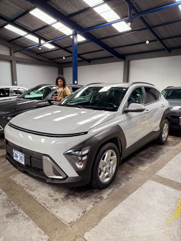 A man doing a final check of the rental car at Adobe SJO office before starting Costa Rica road trip. Renting a car from Adobe at San Jose Airport (SJO).