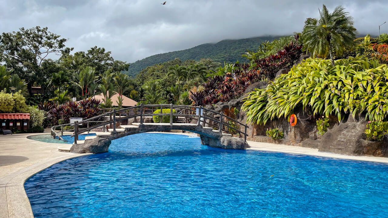 A pool with a wooden bridge at Los Lagos Hotel Spa & Resort in La Fortuna, Costa Rica.