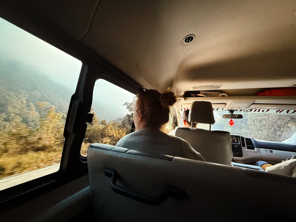 View of dense vegetation from the shuttle window as the vehicle descended the mountain road towards San Pedro La Laguna, Guatemala.