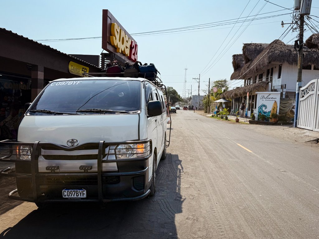 A white minivan parked in front of Super 24 store on the dusty main road of El Paredon in Guatemala.