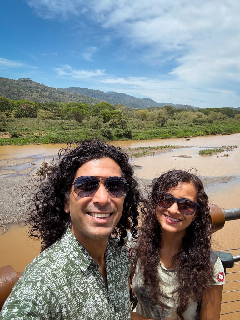 A man and a woman, on the observation deck of Croc Skywalk in Costa Rica. Tarcoles River in the background.