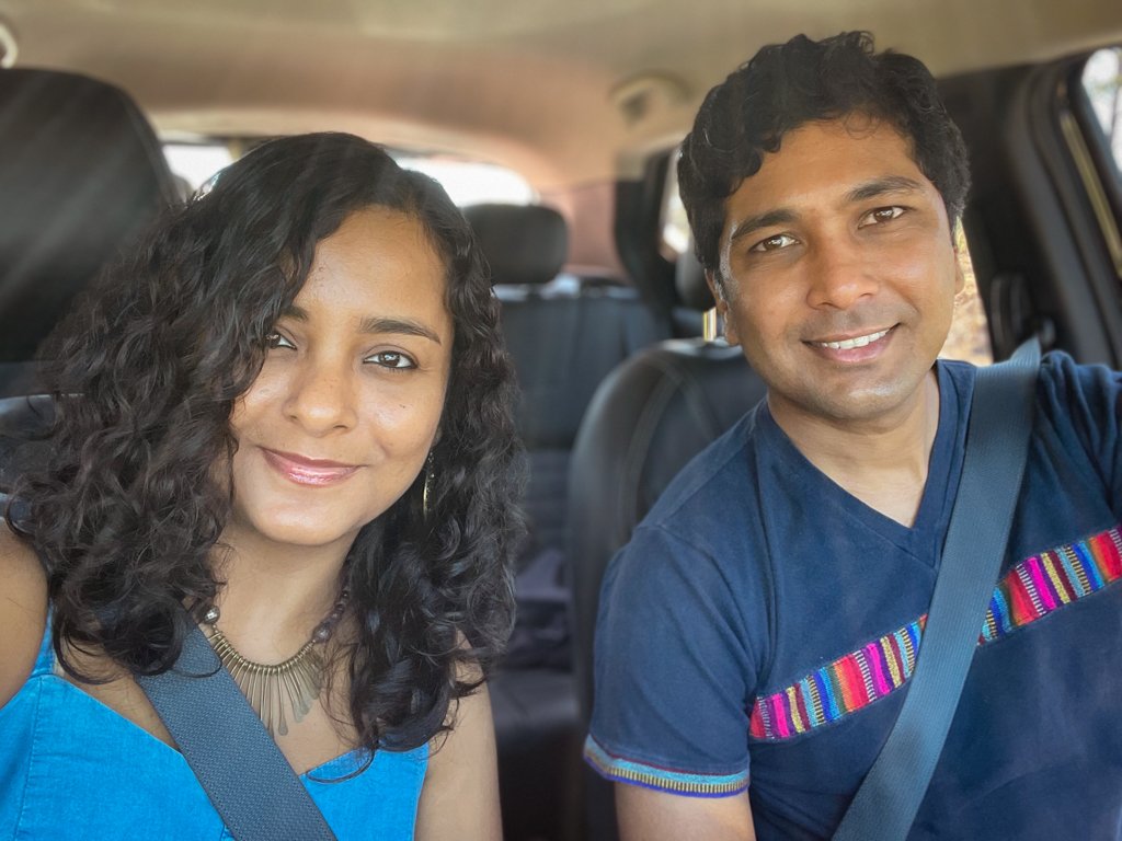 A man and a woman seated inside a car, on a road trip in Costa Rica.