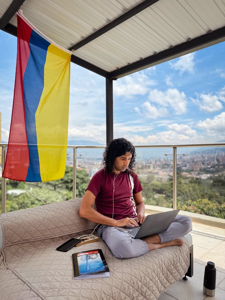 A man working on a rooftop of an accommodation rental in Colombia. Living the digital nomad life in Latin America.